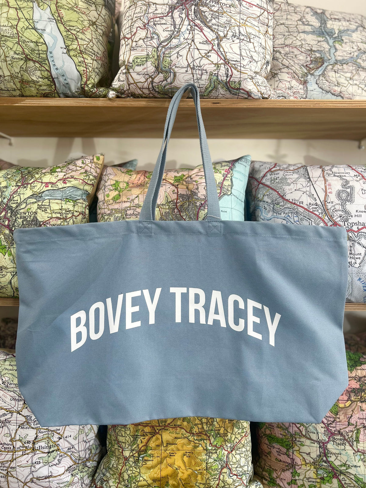 Blue tote bag with 'BOVEY TRACEY' text on a background of vintage maps