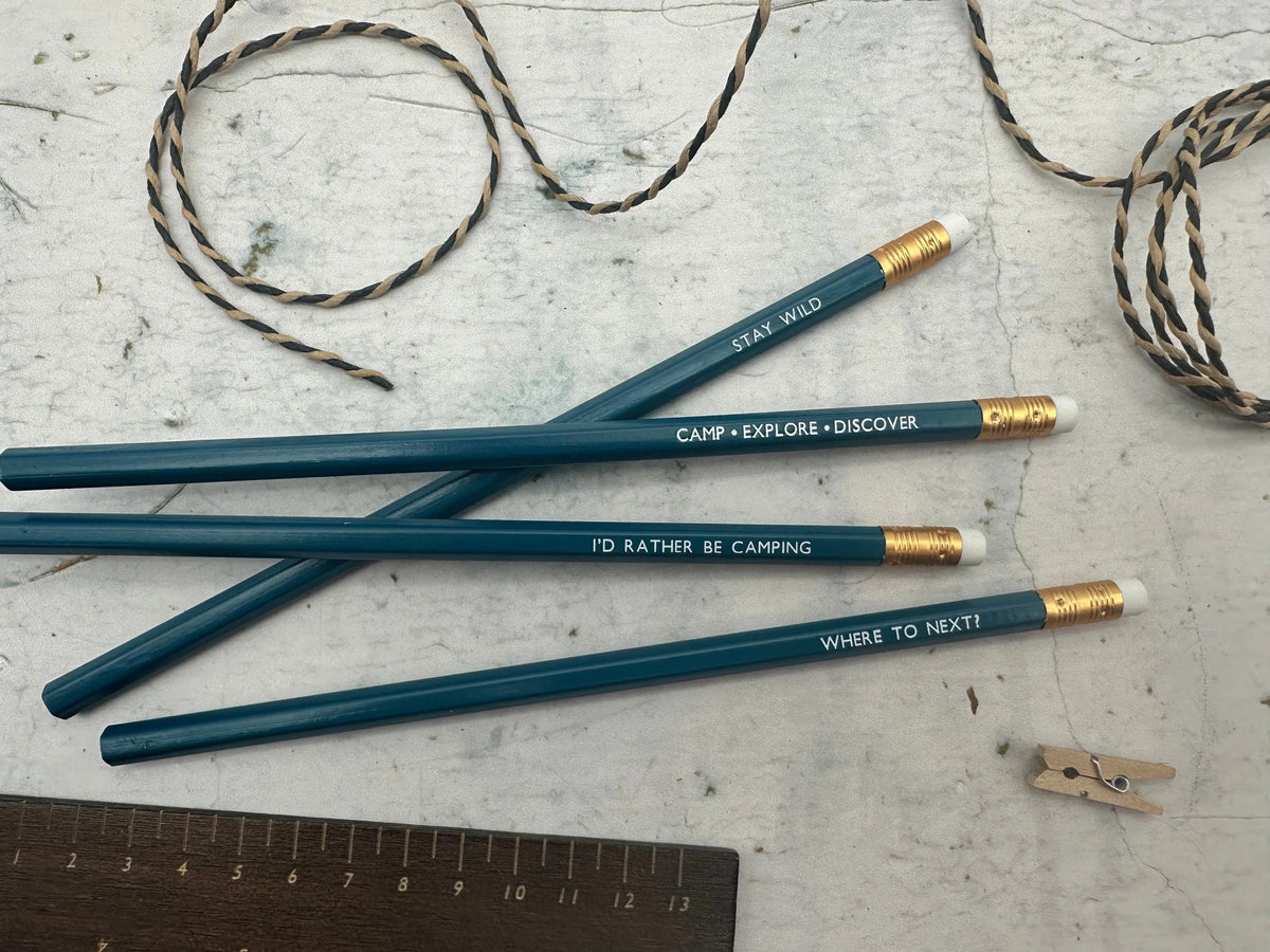 Four teal coloured pencils each with a camping phrase on.