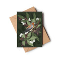 A dark forest green background, featuring an illustration of a chaffinch perched on a branch with green leaves, white flowers, and small purple berries. The card is shown with a brown kraft envelope on a clean white background.