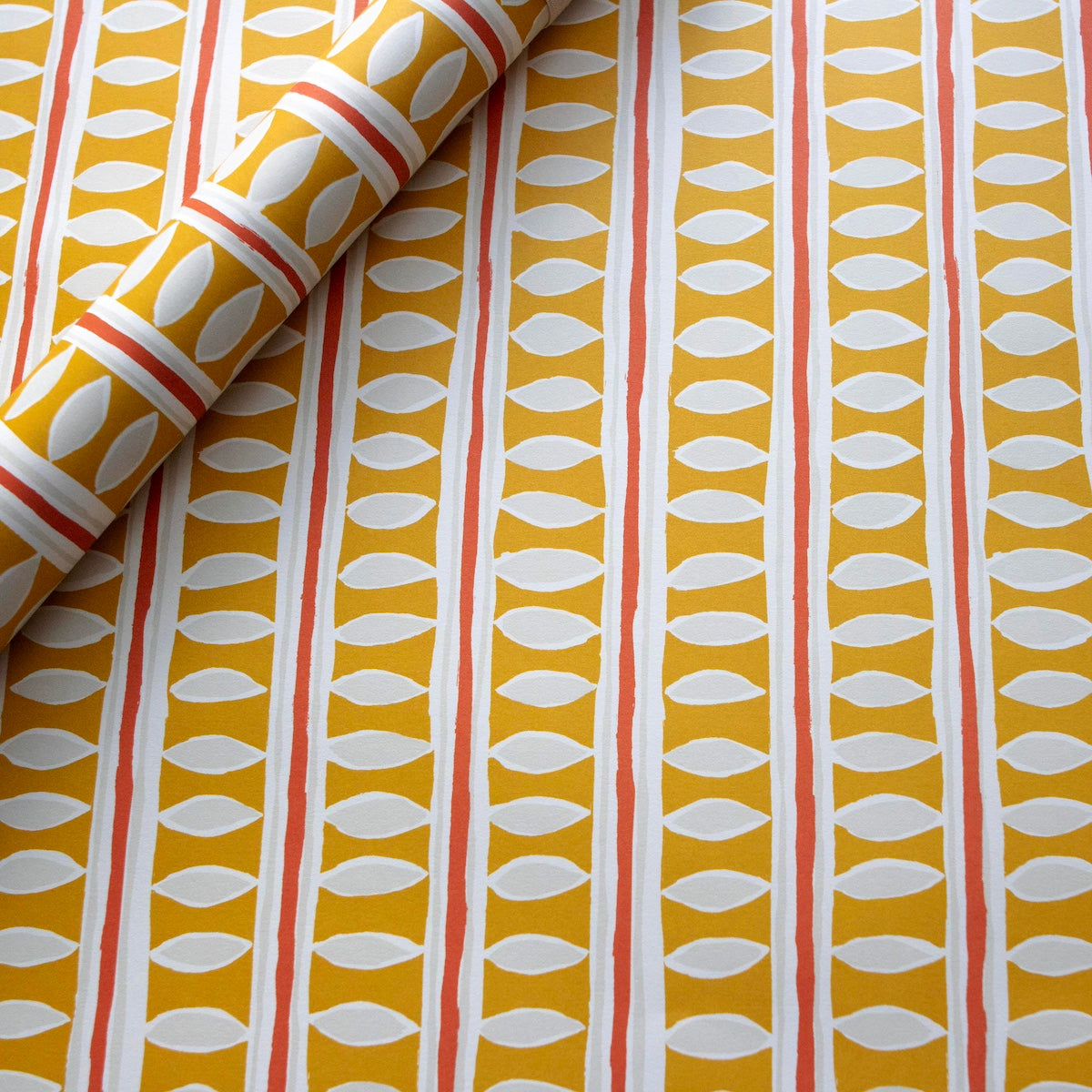 Wrapping paper with a pattern of vertical stripes and leaf shapes on a yellow background