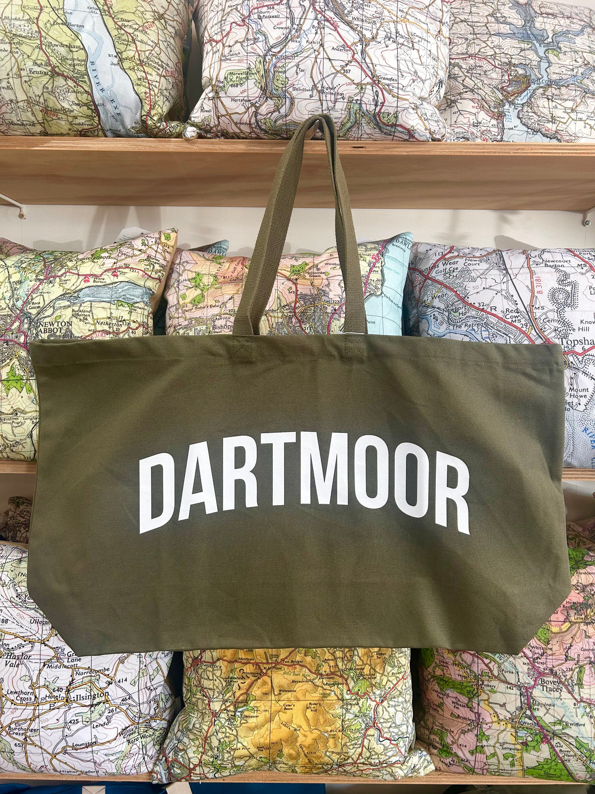 Green tote bag with 'Dartmoor' text on a background of maps