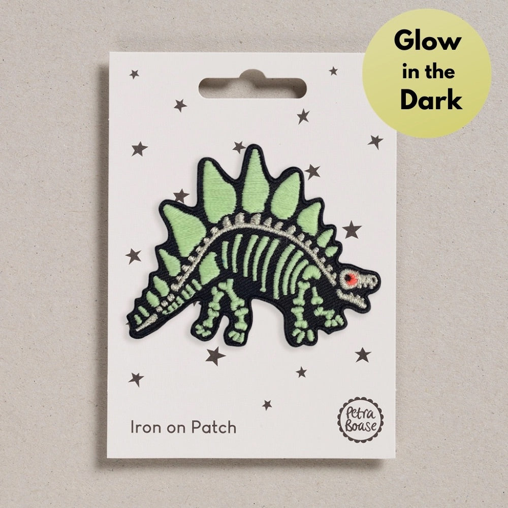 Glow-in-the-dark dinosaur iron on patch on a white card with 'Petra Boase' branding.