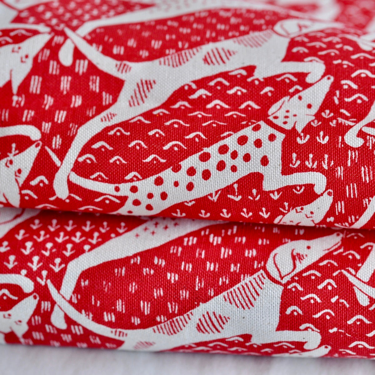 Close up of Dogs Tea Towel in red and cream by Cambridge Imprint
