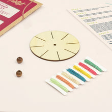 Friendship bracelet-making kit with beads and colourful threads, wooden disc and instructions