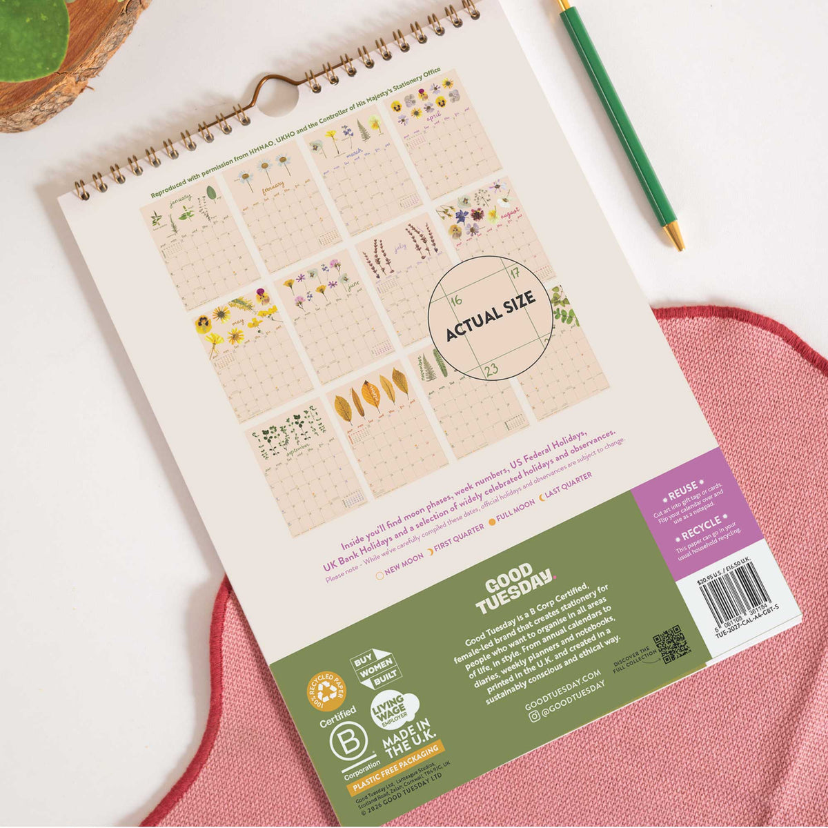 Reverse of garden Botanicals calendar showing monthly page layouts, shown against white background with pink cloth and green pen