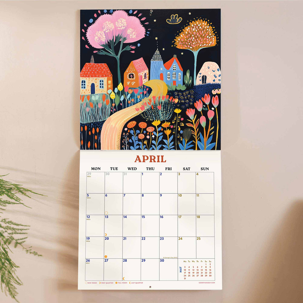 Calendar with a colourful folk style illustration of houses and nature shown on a beige background