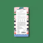 The back of a chocolate bar package by Coco, featuring a pastel pink and blue geometric pattern with a white label, centred on a solid green background.