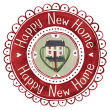 A circular decorative wreath with a scalloped red border and the words 'Happy New Home' repeated around the outer ring. The center shows a small house above a green heart shape on a light background.