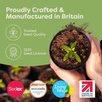 A small potted plant with a green leafy sprig growing in rich soil, held in a person's hands. Large text reads 'Proudly Crafted & Manufactured in Britain' with icons for trusted seed quality and a 1235 seed licence.