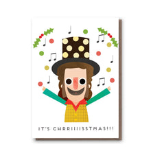 A festive greeting card featuring a stylized illustration of Noddy Holder with arms raised, surrounded by musical notes, holly, and red dots. The card reads 'IT'S CHRRRIIISSTMAS!!!' Slades famous festive song.