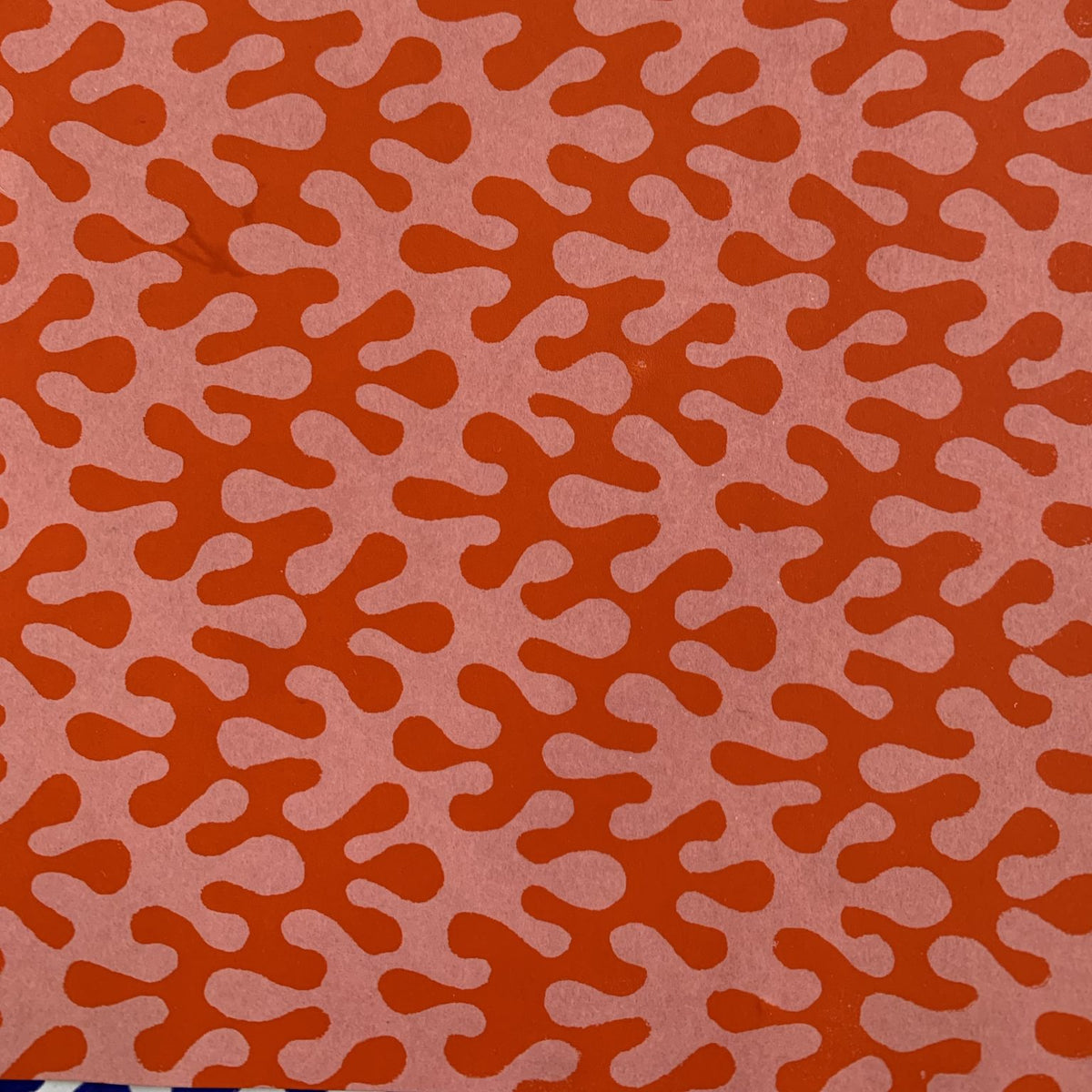 Patterned wrapping paper with red and pink wavy shapes on a matching background