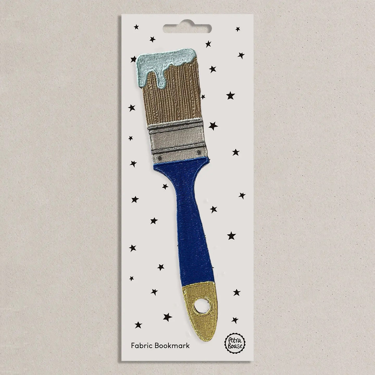 Fabric bookmark shaped like a paintbrush on a white card with star patterns