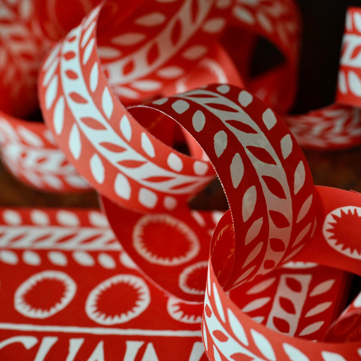 Close up of paper chains in red and white printed leaf design by Cambridge Imprint