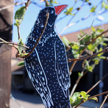 Leather rook shaped bookmark with red beak in tree