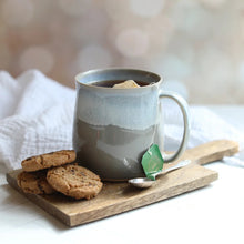 Gray mug with tea and cookies on a wooden board