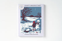 A box of 6 charity Christmas cards that  feature an illustrated winter scene with a child and a snowman in a snowy landscape under a dark blue sky.