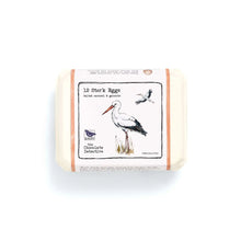 Box of chocolate 'stork' eggs with illustrated sleeve on white background.