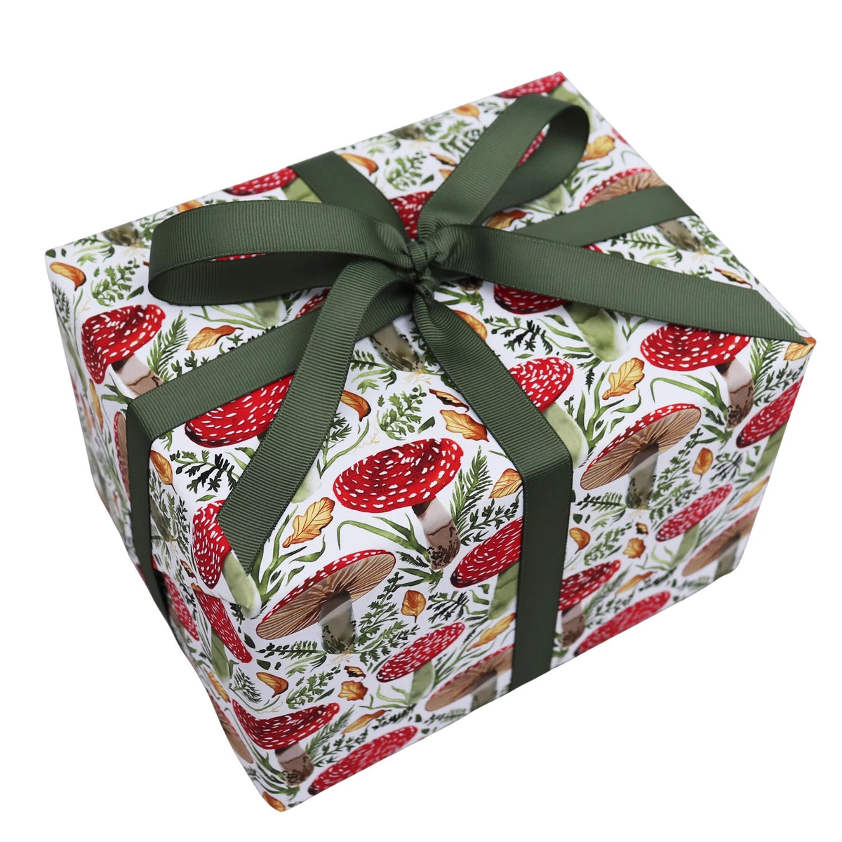 A square gift box wrapped in white paper with a red and green mushroom print, tied with a dark green satin ribbon and bow, on a plain white background.