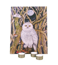 Advent calendar featuring a painted snowy owl perched among bare trees under a full moon, shown against a white background with three small tealight candles in front.